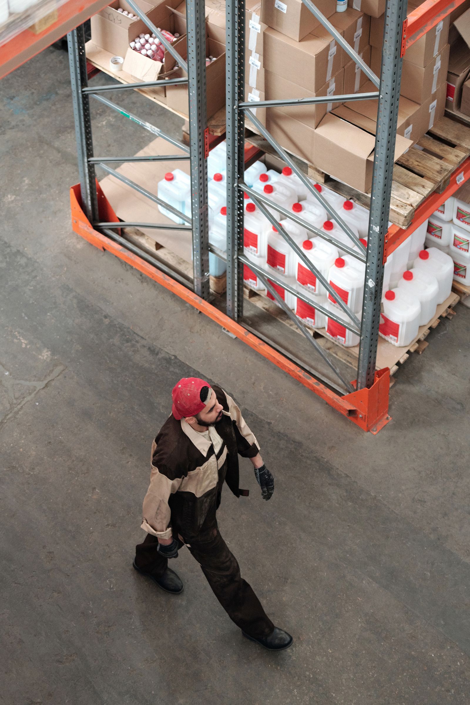 Warehouse worker walking beside shelves of boxed goods